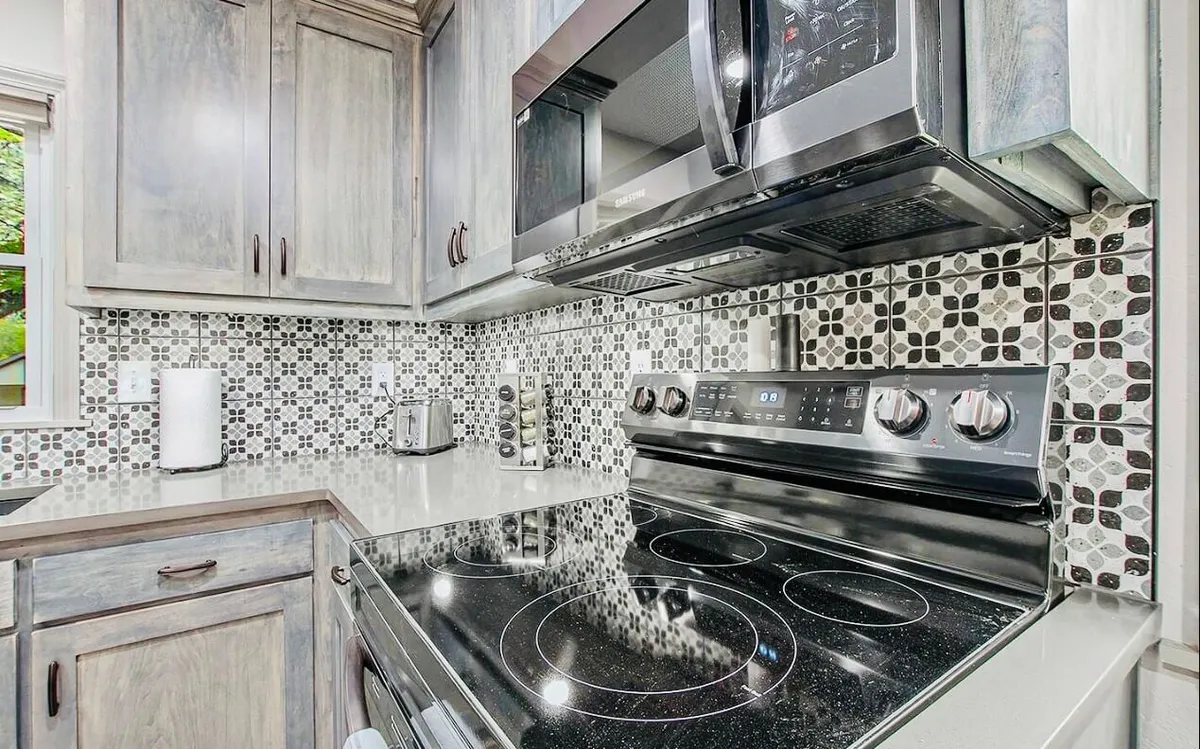 A modern kitchen featuring stainless steel appliances, a decorative backsplash, and a spacious countertop. The layout is ideal for preparing meals together as a family, with ample space for gathering and sharing stories after a day of adventure.