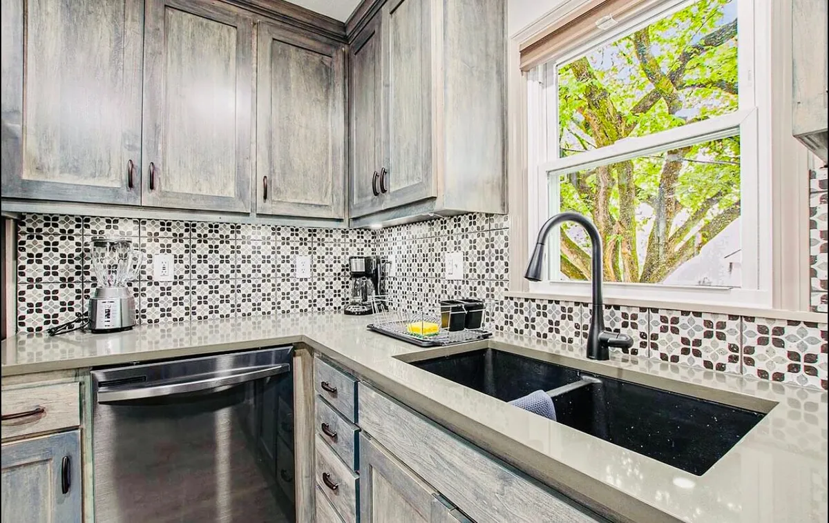 A contemporary kitchen scene highlighting the sink, generous countertop space, and a window that brings in natural light—allowing for tranquil views while preparing meals or enjoying a moment of pause.